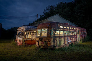 Il fascino rustico di un vecchio tram, con la struttura metallica corrosa e la vernice scheggiata, circondato da una vegetazione selvaggia, che evoca un senso di storia dimenticata.