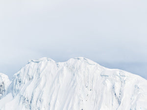 Fine blue shadows tracing a steep white Antarctic mountain face.