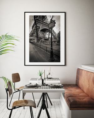 Bare branches cross the Eiffel Tower behind an Avenue Gustave Eiffel sign.