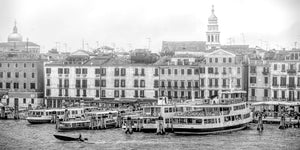 Venetian waterfront buildings and docked boats beside rippling canal water