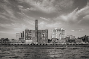 The Domino Sugar refinery and tall chimney across rippled East River water.