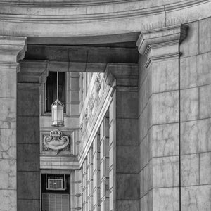 Stone columns frame a narrow view of an ornate Buenos Aires building.