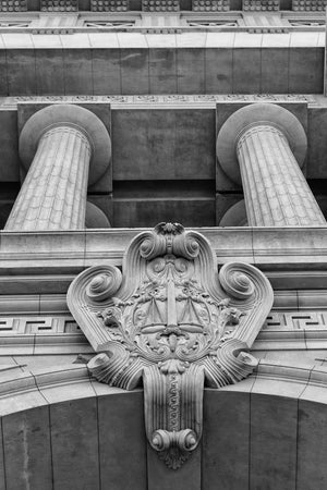 Classical columns and carved stone scales on a Buenos Aires facade in monochrome.