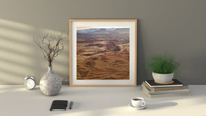 Canyonlands landscape photograph showing warm rock layers and a hazy desert horizon.