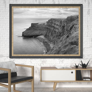 Overcast light softens a broad view of the Cliffs of Moher and the water below.