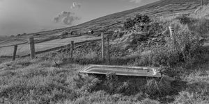 Weathered fences and an old bathtub across a sloping County Kerry hillside.