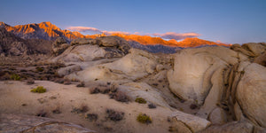 Panoramic photograph of sunrise on the Eastern Sierra with desert rocks in the foreground