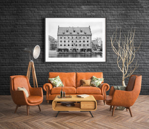 A steep tiled roof rises above repeated windows in a monochrome Polish architectural photograph