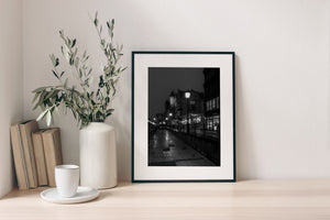 A quiet Polish riverside walk leads past historic towers and illuminated shop windows