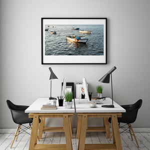 Colour waterfront photograph of anchored fishing rowboats and sunlit ripples in Havana, Cuba.