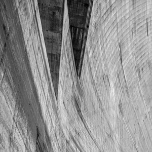 Hoover Dam concrete surfaces form strong curves and dark channels in a monochrome close-up.