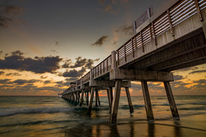 Florida pier pilings above waves at sunrise