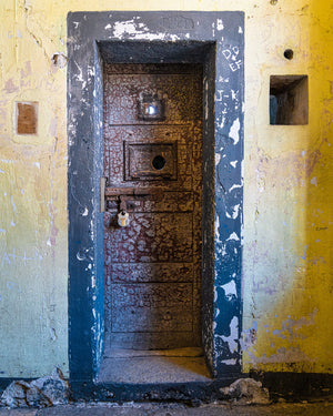 Weathered prison door set in yellow walls at Kilmainham Gaol
