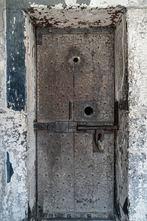 Cracked paint and metal studs on a historic Dublin prison door