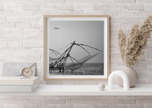 Monochrome fishing-net structures with birds crossing the sky