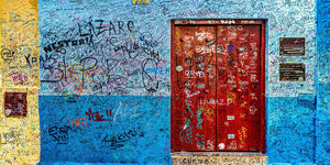 Colour panorama of layered signatures across a blue Havana wall and red door.