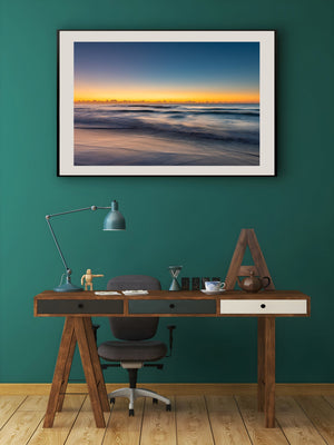 Gentle waves approaching Long Reef Beach under a blue and gold dawn sky
