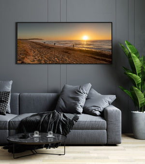 Long Reef Beach shoreline with scattered walkers and a bright morning sun