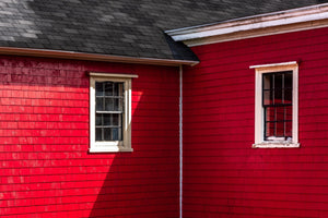 Sunlight and shadow cross the red wooden shingles of a Lunenburg house