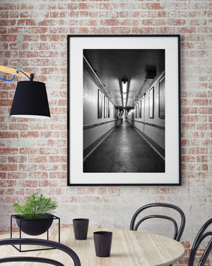 New York station corridor with handrails and framed advertisements in black and white