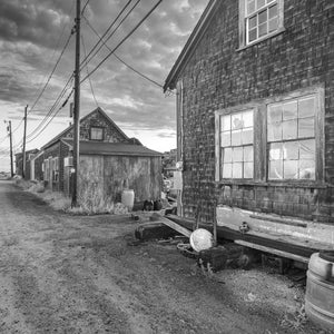 Quiet gravel lane beside shingled fishing shacks on Martha’s Vineyard