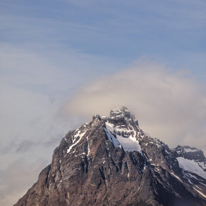 Colour photograph of a jagged mountain peak partly obscured by mist