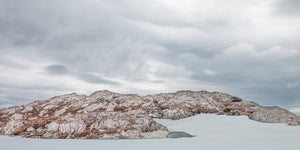 Colour mountain panorama with pale exposed rock and smooth snowfields
