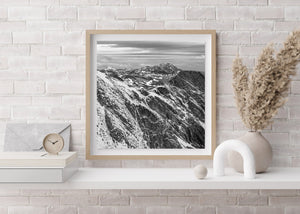 Monochrome photograph of rugged ridges and distant jagged peaks