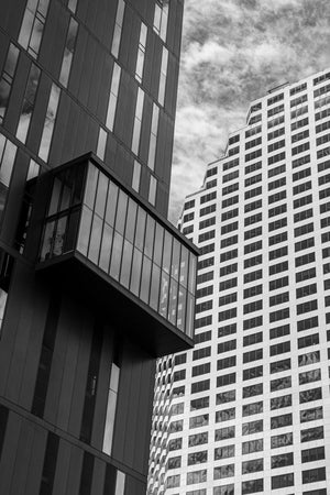 A dark glass building contrasts with a stepped white office tower