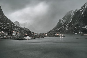 Moody view of Reine village beside calm water in Norway