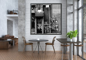 Black and white urban photograph of layered graffiti and street art
