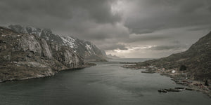 Moody coastal panorama with cliffs and a small shoreline settlement