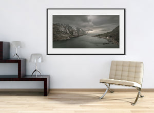Snow-streaked mountains bordering a quiet Norwegian inlet