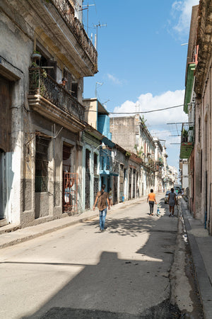Sunlit Havana street with aged facades and a blue sky