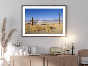 Snow-capped mountain range beyond a rustic trailer shelter
