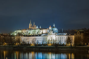 Prague’s lit riverside buildings reflected in the dark Vltava River