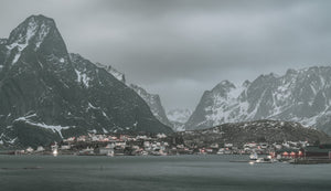 Coastal village of Reine below steep snow-streaked peaks in Norway