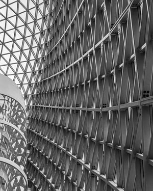 Repeating triangular braces beside curved glass balconies at SAHMRI