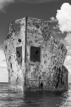 Weathered bow of SS Sapona with exposed reinforcing rods and graffiti.