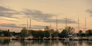 Sailboats moored along Toronto Island docks under a warm dusk sky