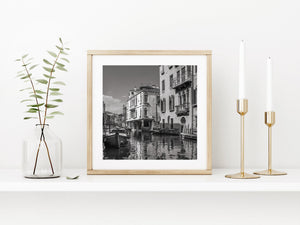 Black and white canal scene with historic Venetian houses and small boats