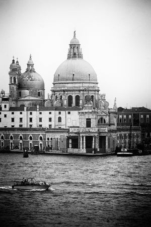 A small motorboat passes beneath the domes of Santa Maria della Salute