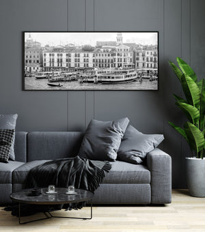 Monochrome canal panorama with a bell tower, tiled roofs and docked vessels