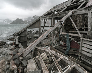 Rimessa per barche in legno crollata con reti da pesca e una barca di legno alle Lofoten