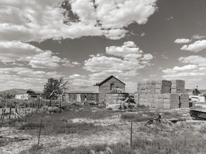 Edifici di ranch in legno esposti alle intemperie e un alto pagliaio in Nevada, in bianco e nero