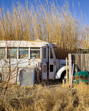 Vieux bus blanc à côté d'une clôture en bois sous un ciel bleu clair de Californie