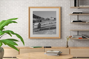Small timber barns among winding fences on a rural Romanian slope