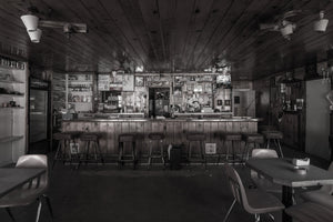 Monochrome diner interior with a wooden counter and rows of empty seats