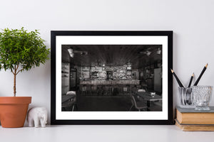 Quiet restaurant interior with bar stools menus and a wood panelled ceiling