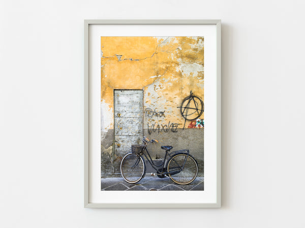 Old bicycle with basket against graffiti wall in Rome
